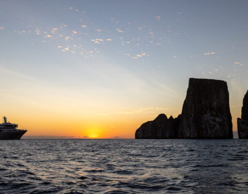 Silver Origin approaching Kicker Rock at sunset, Galapagos Islands.